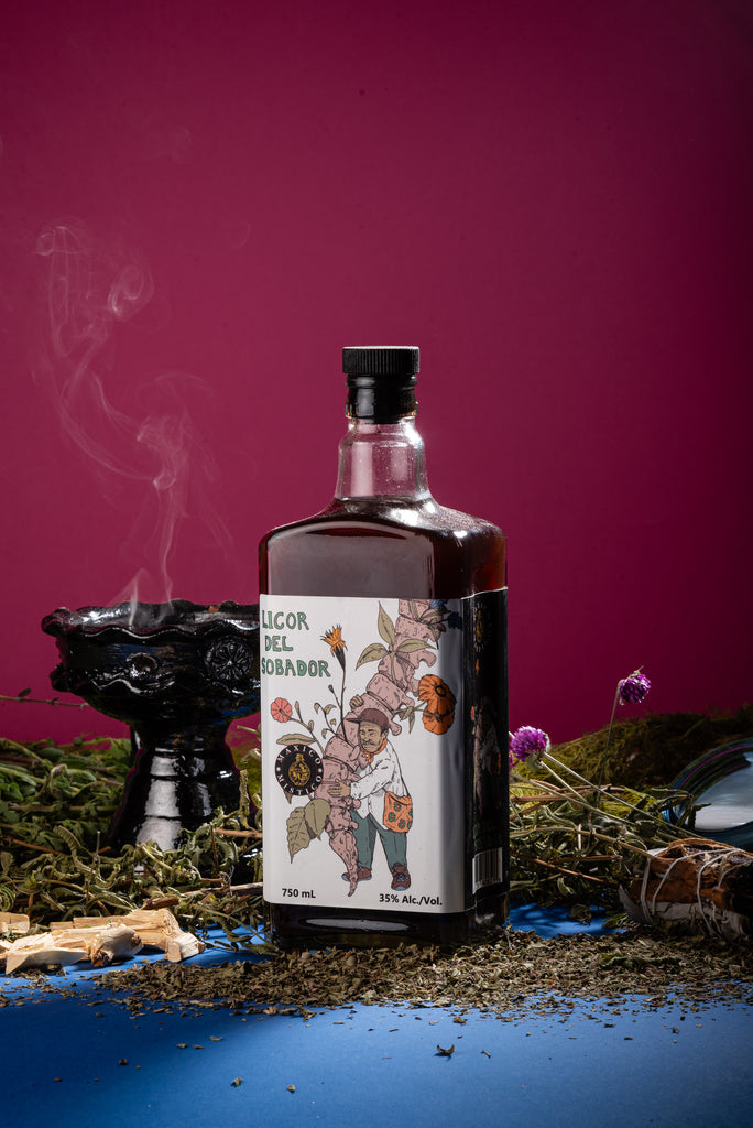 Bottle of Licor del sobador  with decorative label on a mystical setup with smoke and plants.
